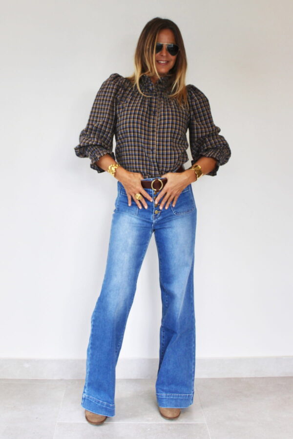Camisa nido de abeja de cuadros marrones con mangas abullonadas, combinada con vaqueros acampanados y cinturón