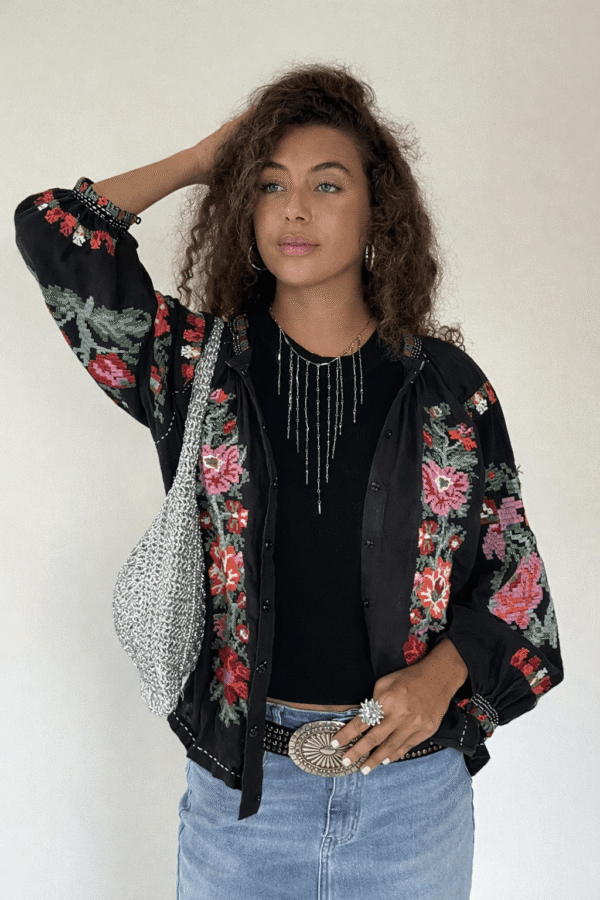 Camisa bordada negra con flores rojas y rosas en punto de cruz, vista de frente