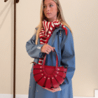 Mujer con gabardina azul y bufanda de rayas con el Bolso Abanico Soleil rojo