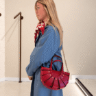Bolso Abanico Soleil rojo colgado al hombro con cadena dorada, vista de perfil