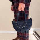 Bolso Abanico Soleil azul marino llevado de la mano con pantalón de cuadros