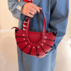 Bolso Abanico Soleil rojo llevado de la mano con gabardina azul
