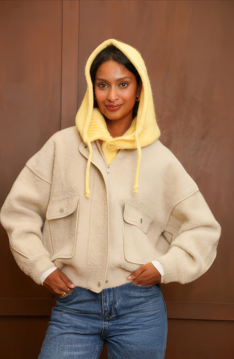 Balaclava de punto amarilla con cordones, sobre chaqueta crema y vaqueros