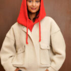 Balaclava de punto roja con cordones, sobre chaqueta crema