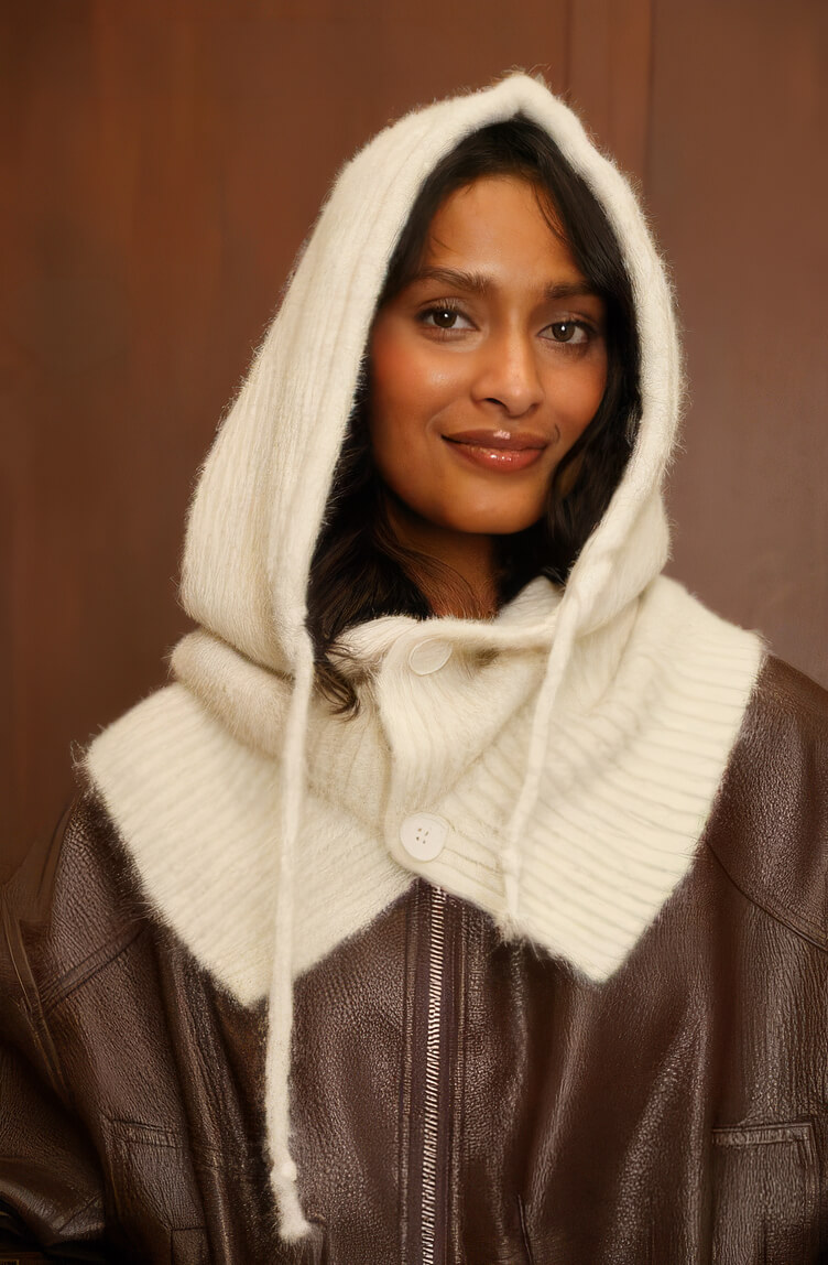 Balaclava de punto color crema con cordones, sobre chaqueta de cuero marrón