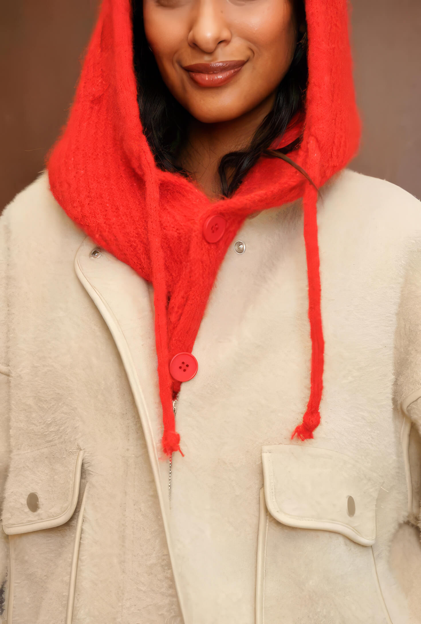 Detalle de la balaclava de punto coral con botón rojo