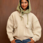 Balaclava de punto verde agua con botones, sobre chaqueta crema