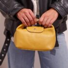 Detalle de la cazadora Bowie con cinturón de hebilla y bolso de piel mostaza