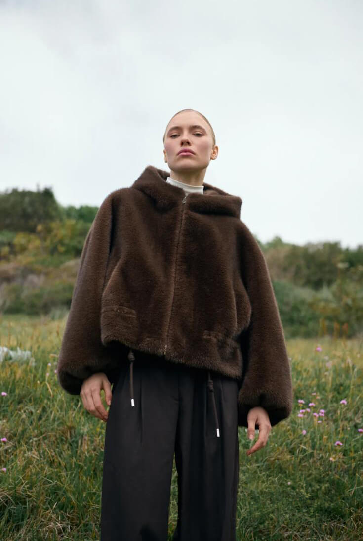 Chaqueta Yeti de pelo marrón con cremallera y pantalón negro, en exterior