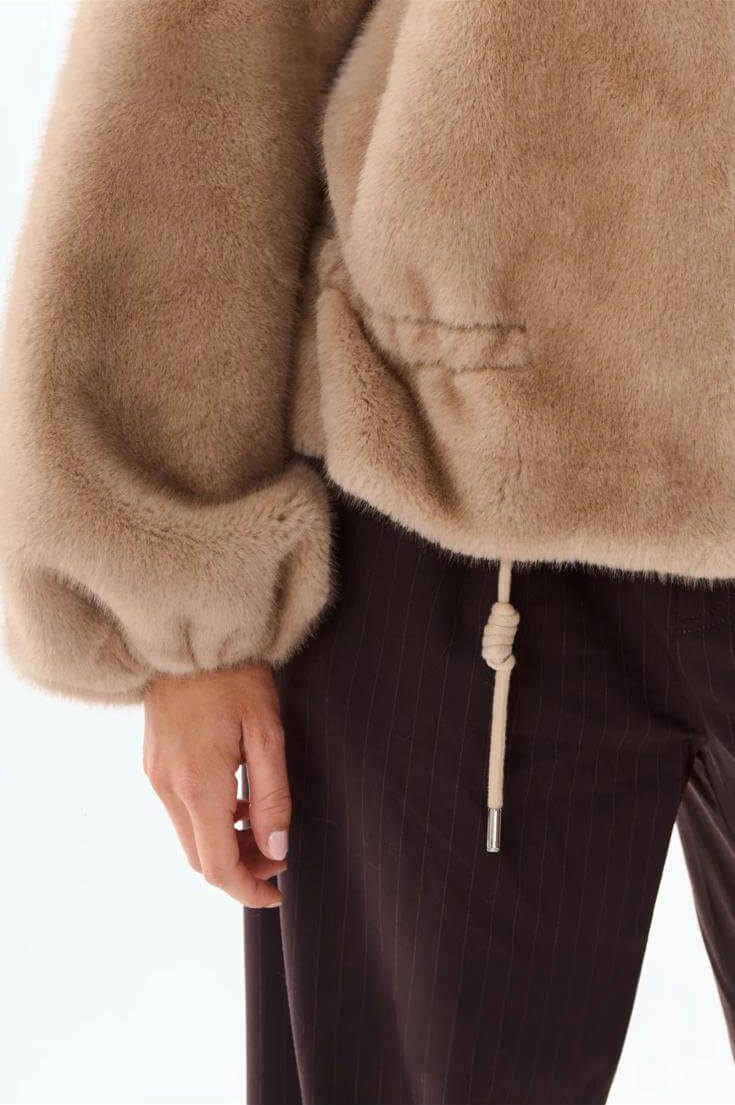 Detalle del puño abullonado y el cordón de la chaqueta Yeti beige