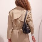 Espalda de la gabardina Amulet beige con canesú y bolso negro al hombro