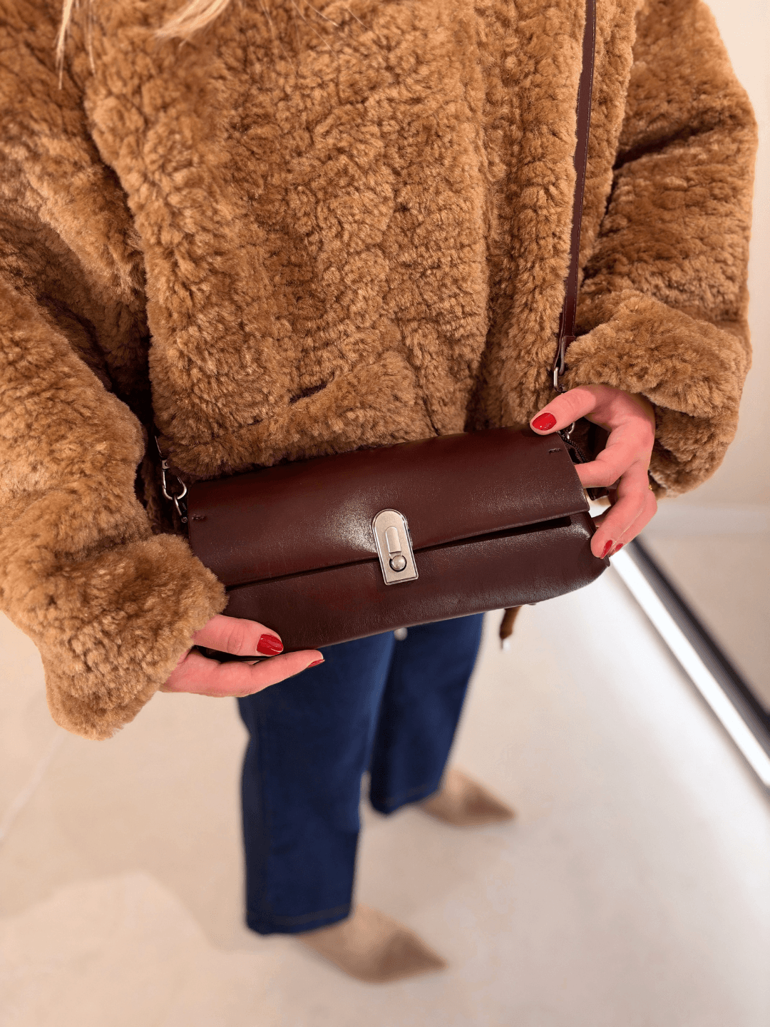 Bolso Dakota en burdeos cruzado sobre chaqueta de pelo camel