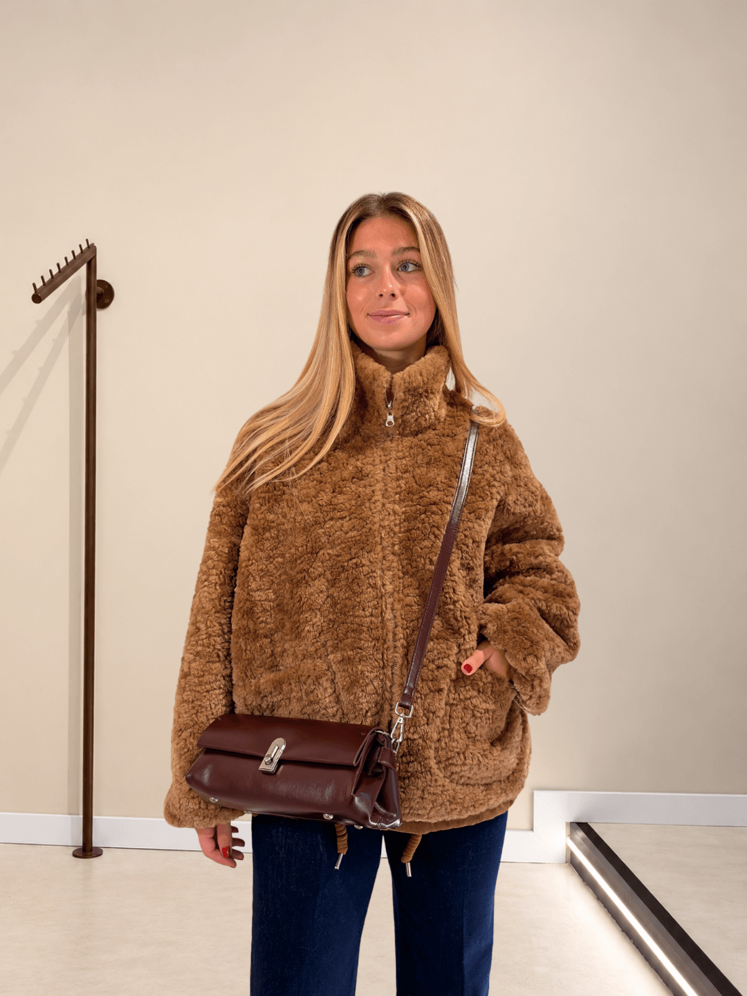 Bolso Dakota burdeos en bandolera con chaqueta de pelo y vaqueros
