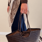 Bolso Indira de piel trenzada con interior de saco y cordón, llevado de la mano