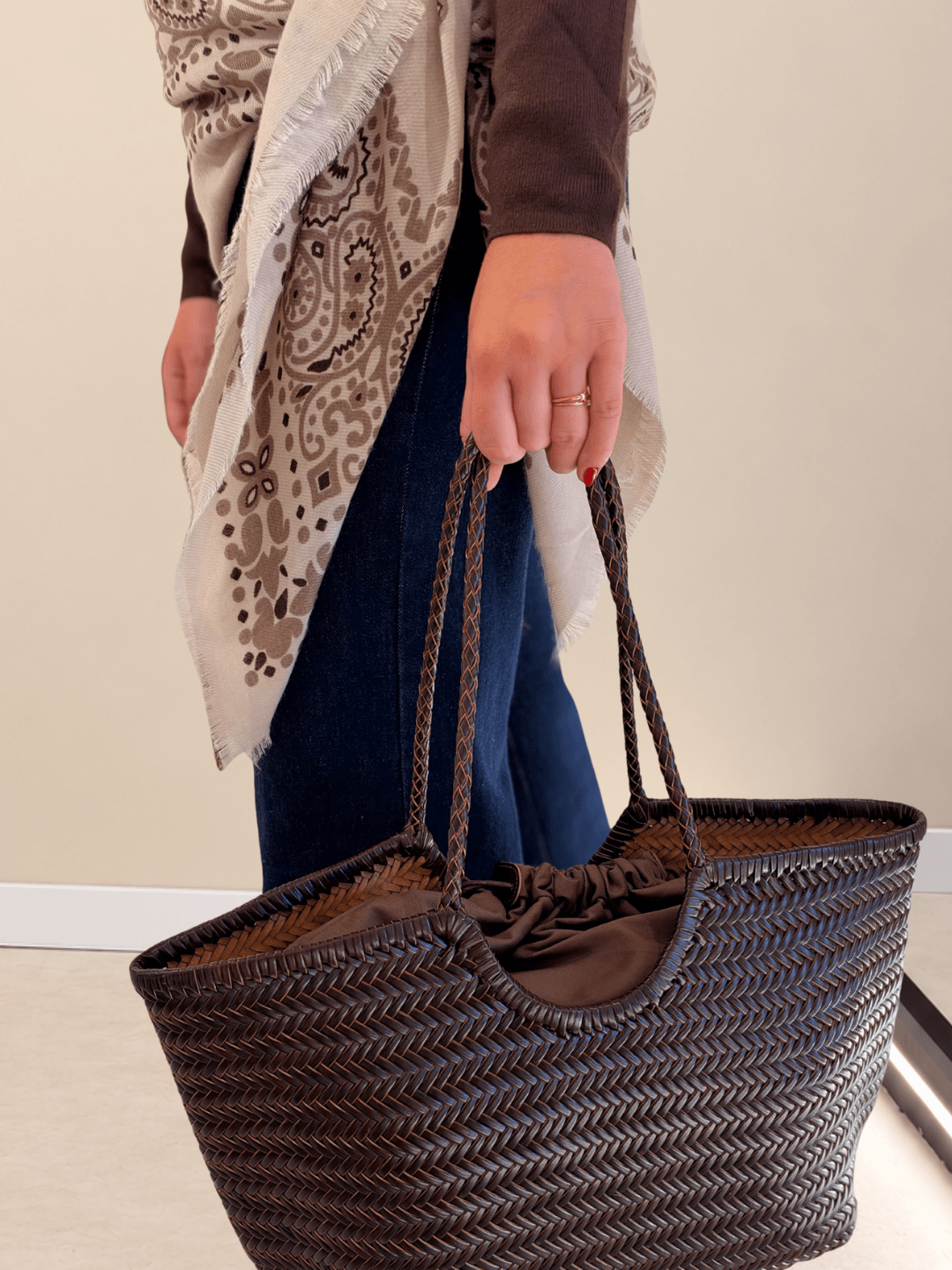 Bolso Indira de piel trenzada con interior de saco y cordón, llevado de la mano
