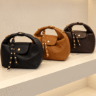 Bolsos Media Luna en negro, camel y marrón expuestos en la tienda Carolé