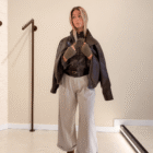 Chaqueta Biker marrón de polipiel sobre los hombros con pantalón ancho gris, vista completa