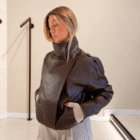 Chaqueta Biker marrón de polipiel cruzada con la mano en el bolsillo, vista lateral