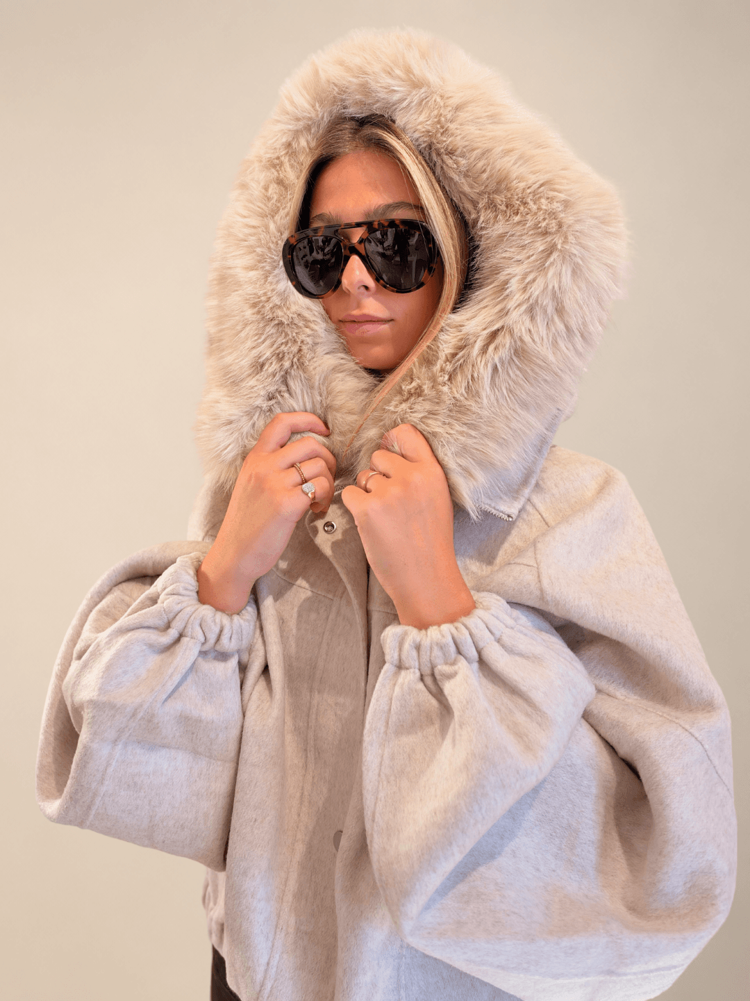 Chaqueta Yvette de lana y cachemir crudo con capucha de pelo y gafas de sol, plano cercano