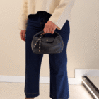 Bolso Media Luna de piel italiana azul marino colgado de la mano con vaqueros culotte