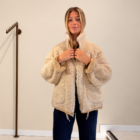 Abrigo Dakota reversible beige de pelo abrochándose el cuello