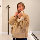 Abrigo Dakota reversible beige de antelina cerrándose el cuello de borreguito