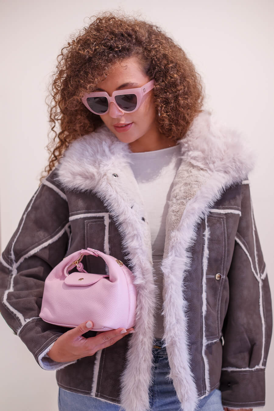 Detalle del Bolso Media Luna de piel italiana rosa con chaqueta de borreguito