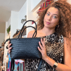Mujer con vestido de leopardo mostrando el Bolso Indira negro