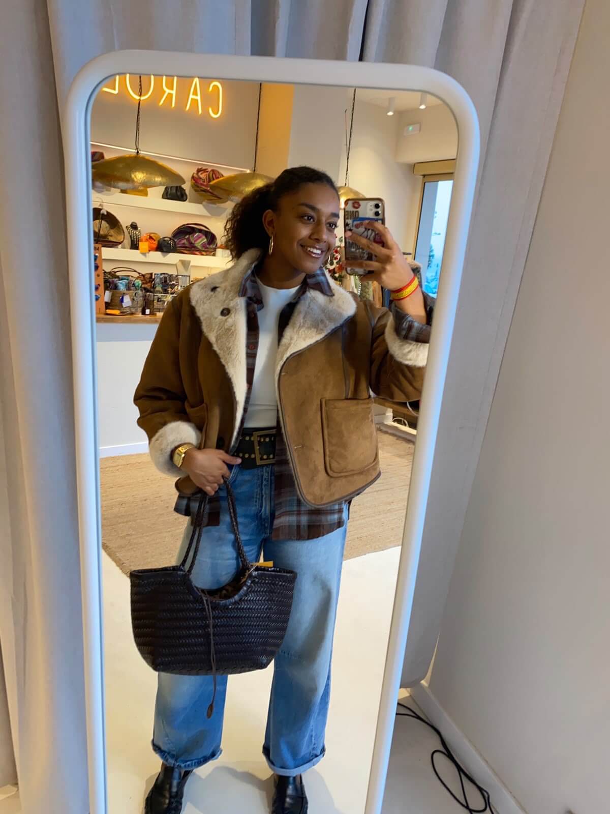 Clienta haciéndose una foto en el espejo de la tienda Carolé con el Bolso Indira